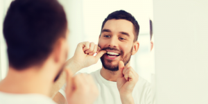 'man flossing teeth'
